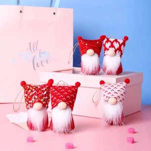 Detail of five handmade Christmas gnome ornaments with red and white knitted hats and twine loops