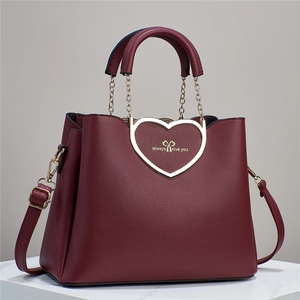 Detail of burgundy heart-shaped gold buckle with always love you engraving and litchi texture