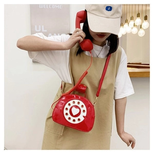 Detailed view of creative red telephone crossbody bag with glossy finish and heart dial decoration