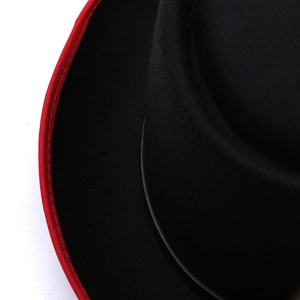 Detail of red fabric piping on black felt hat brim with precise stitching