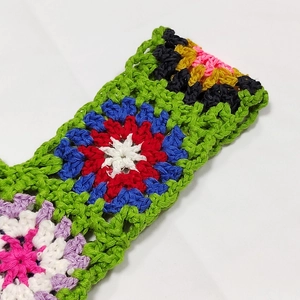 Close-up of colorful handmade crochet grandmother square patterns with detailed stitching