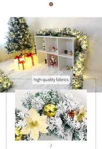 Macro detail of snow-flocked Christmas garland with LED lights and golden ornaments