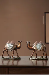 Detailansicht exotischer Kamelfiguren aus Harz mit verzierten Gold- und Silberprägungen