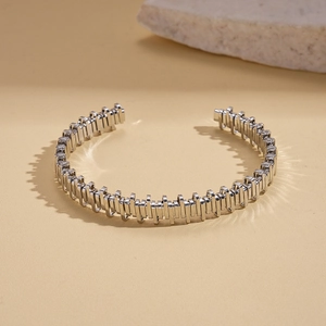 Detail view of silver industrial-style cuff bracelet with vertical geometric textures