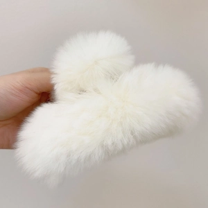 Close-up of a plush white faux rabbit fur hair claw clip for elegant autumn winter styles
