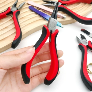 Detailed view of hand holding professional red and black DIY jewelry pliers for crafting
