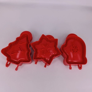 Three red plastic 3D Christmas cookie cutters in tree, snowflake star and glove shapes