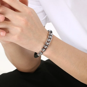 Close-up of punk style braided leather bracelet with engraved skull metal beads for men