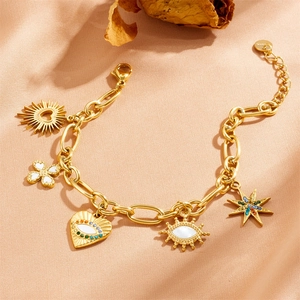 Detail of gold evil eye bracelet featuring butterfly, heart, and star charms on silk