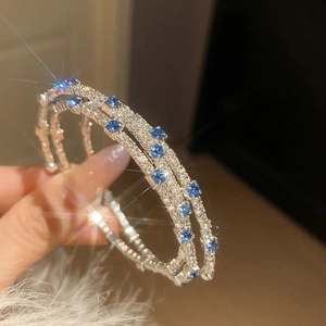 Detailed macro view of S925 silver hoop earrings with blue and clear sparkling zircons