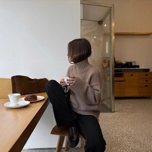 Minimalist brown turtleneck sweater styled with black trousers and leather loafers