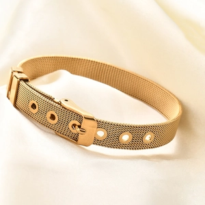 Golden stainless steel mesh bracelet with adjustable buckle on white silk background