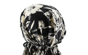 Detail view of pre-tied turban cap with vintage black and white floral print texture