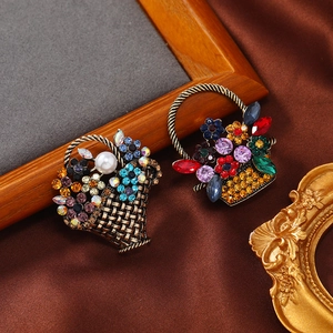 Vintage flower basket brooches with colorful rhinestones and pearls on a retro background