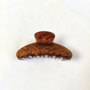 Detail van het bruine schildpadpatroon op een grote haarklem voor dames en meisjes