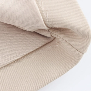 Close-up of the elegant beige knitted fabric showing premium stitching and texture details