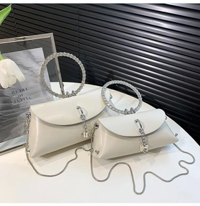 Detail of the chic cream evening bag with a crystal beaded round handle and metal chain