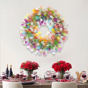 Pastel tinsel Easter wreath with colorful egg ornaments hanging on a white wall decoration