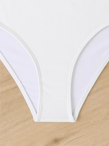 Detail of white ribbed fabric texture and professional stitching on the bikini bottom
