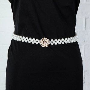 Close-up of elegant elastic pearl waist chain with a sparkling crystal flower buckle