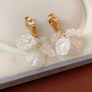 Detail of gold petal tassel earrings with iridescent finish on jewelry box display