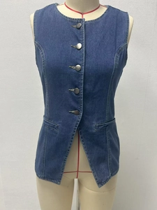 Detail of vintage dark blue denim vest featuring metal buttons and symmetric front pockets