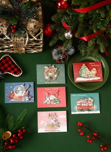Detail view of colorful cartoon Christmas cards with Santa and tree on green background