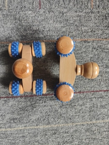 Nahaufnahme von Massage-Rollern aus Holz mit blauen Zahnrädern zur Meridian-Massage