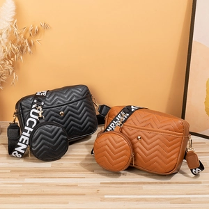 Quilted crossbody bag set with wide shoulder strap and round pouch in brown and black