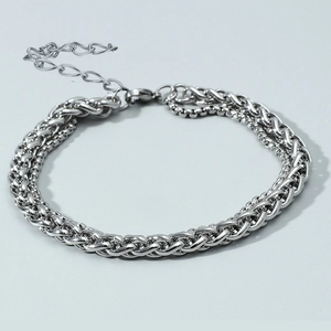 Detail of silver double-layered stainless steel bracelet with woven and box chain textures