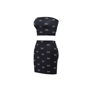 Detail of black tube top and mini skirt set with white bow prints and slim fit design