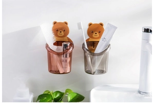 Detail of bear-shaped wall-mounted toothbrush holders with drainage holes in bathroom