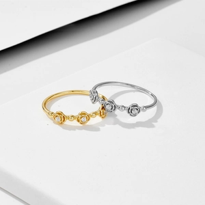 Sparkling diamond rose silver rings in gold and silver finish on stone base
