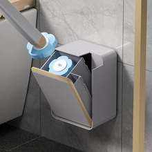 Close-up of wall-mounted gray toilet brush holder with blue floral patterned brush head