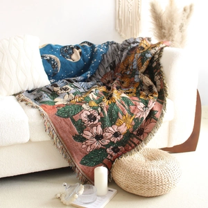 Detail of bohemian knit throw with floral moon pattern and colorful fringe on a sofa