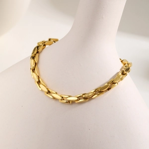 Macro view of flat oval interlocking links in polished gold-plated stainless steel