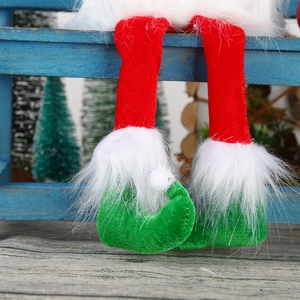 Detail of plush Christmas elf legs with red velvet pants, green shoes and white faux fur