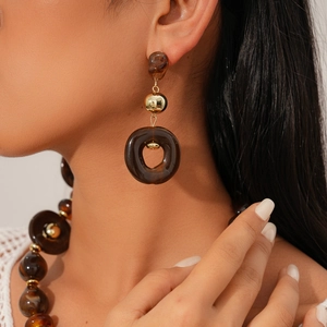 Detail of amber resin beads and gold metal spheres on vintage pendant earrings