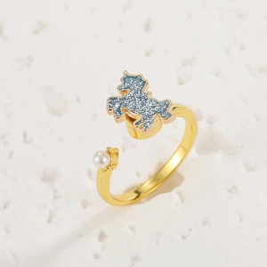 Detail of adjustable gold ring featuring a blue glitter unicorn and white pearl accent
