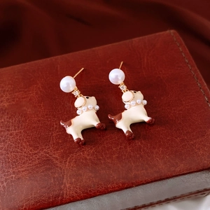 Détail macro de boucles d'oreilles chiot avec émail, perles et cristaux