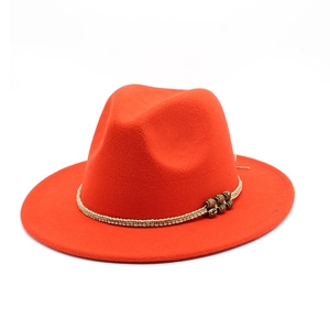 Close-up of a red wool fedora featuring a beige woven rope band with vintage metal beads