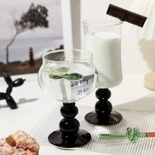 Detail of unique glass ice cream bowls with black spherical stems and dessert presentation