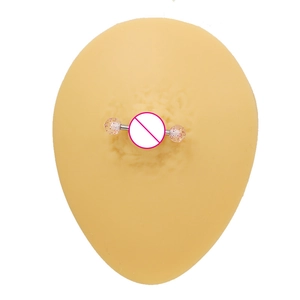 Détail macro d'un piercing de téton à perles roses sur modèle de sein en silicone