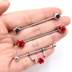 Vista macro di barbell industriali argentati con dettagli di rosa rossa e cuore di strass