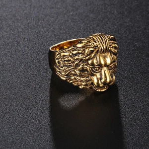 Macro shot of 3D lion head relief on wide golden titanium steel ring showing metal texture