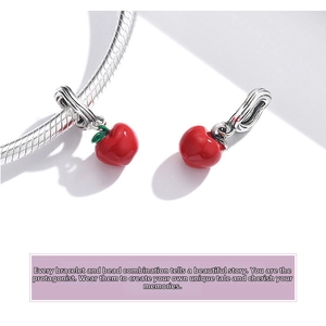 Detailed macro view of 925 sterling silver snake chain bracelet with red apple charms