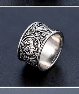 Macro shot of vintage silver ring with detailed mythical beast relief carvings and patterns