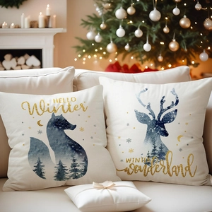 Detail of linen pillow covers with winter fox and deer prints by a cozy fireplace