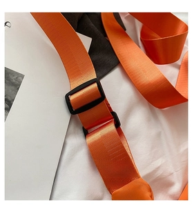 Detail of adjustable vibrant orange nylon shoulder strap with durable black buckle