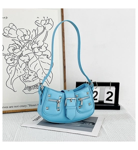 Close-up of light blue motor-style bag with silver rivets and buckle detail